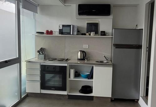 a small kitchen with a stove and a refrigerator at Aptos FRERS 3 in Martínez