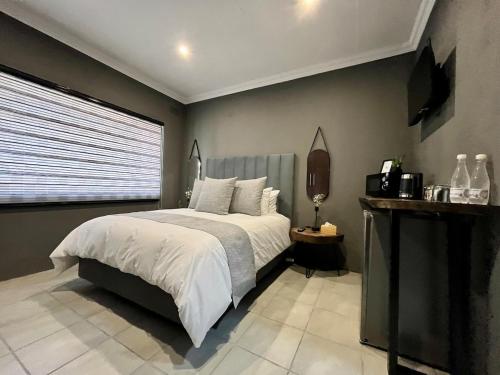 Un dormitorio con una cama grande y una ventana. en OR Tambo Guest Retreat Unit 3, en Boksburg