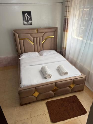 a bedroom with a bed with two towels on it at Nkubu Homes in Nkubu