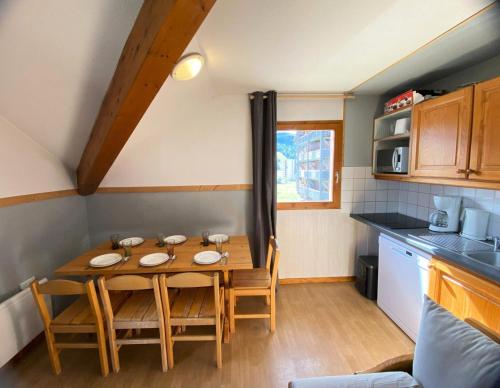 a small kitchen with a table and chairs in a room at Les Chalets De Superd Bleuet - APPARTEMENT 4 PIECES 8 PERSONNES EXPO SUD MAE-8824 in Le Dévoluy