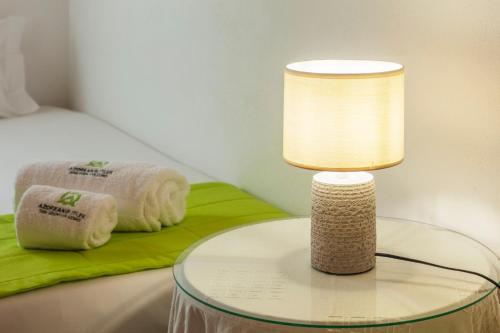 a table with a lamp and towels on a bed at Casas do Porto in Mosteiros
