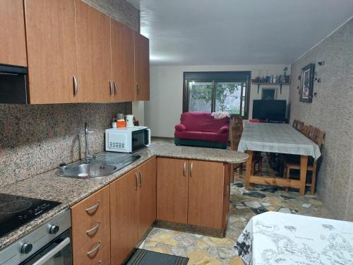 VilladesusoにあるCasa con piscina al lado del mar en Viladesusoのシンクと電子レンジ付きのキッチン