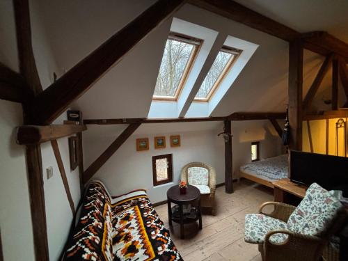 a living room with a couch and some windows at Dom Przytulisko in Janowiec