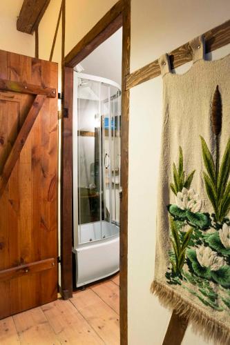 a bathroom with a shower and a glass door at Dom Przytulisko in Janowiec