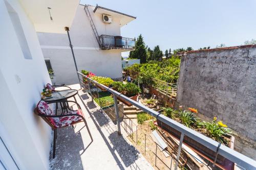 a balcony with a table and chairs and flowers at Apartments Amijova in Bar