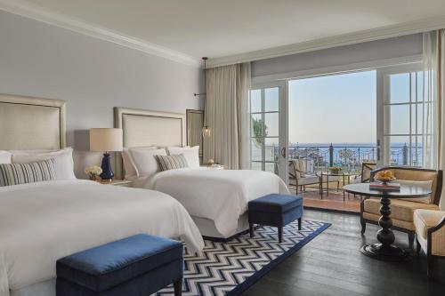 a hotel room with two beds and a balcony at Rosewood Miramar Beach in Santa Barbara