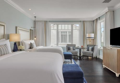 a hotel room with two beds and a flat screen tv at Rosewood Miramar Beach in Santa Barbara