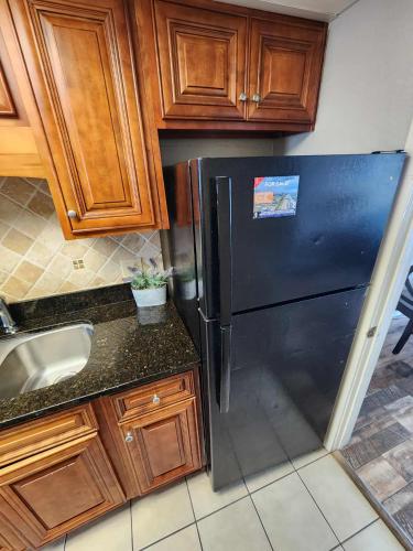 a kitchen with a black refrigerator and wooden cabinets at Landmark 1134 in Myrtle Beach