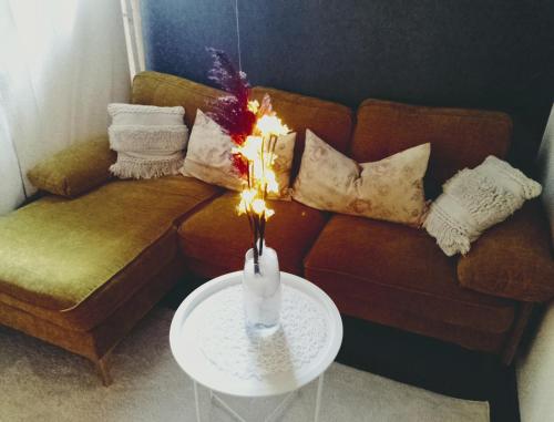 a living room with a couch and a table with a candle at Jules Heim mit Herz in Hanshagen