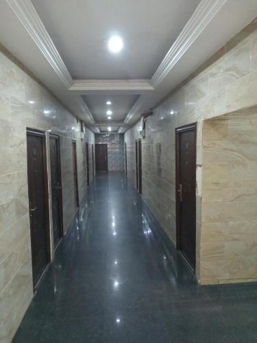 a hallway of a building with doors and tile walls at AFRICAN PRINCESS HOTEL, New Haven in Enugu