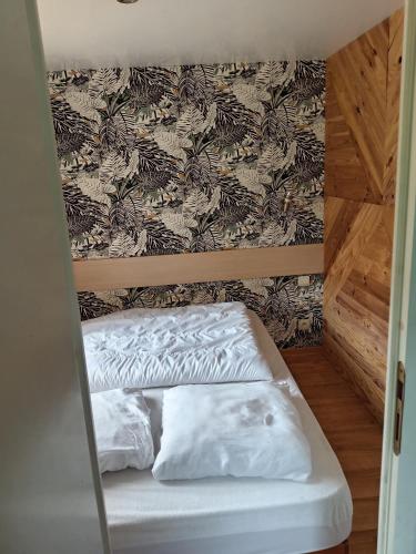 a bunk bed with two white pillows in a room at Entre campagne et forêt à 900m du zoo et au pied des pistes cyclables in La Flèche