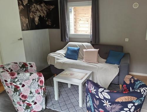 a living room with two chairs and a couch at Entre campagne et forêt à 900m du zoo et au pied des pistes cyclables in La Flèche
