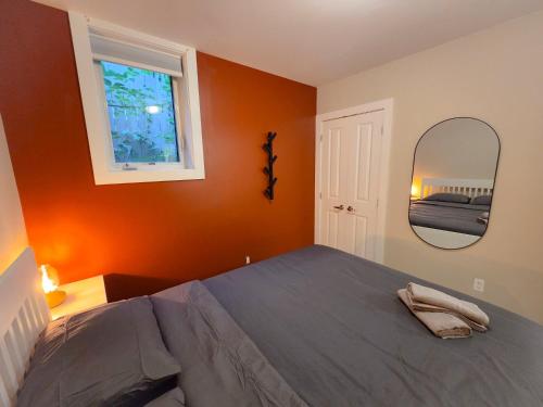 a bedroom with a large bed and a mirror at Sandy Hill Downtown Guesthouse in Ottawa