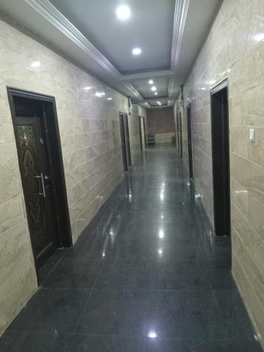 a hallway of a building with doors and tile walls at AFRICAN PRINCESS HOTEL, New Haven in Enugu