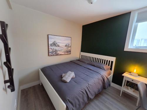 a bed in a bedroom with a green wall at Sandy Hill Downtown Guesthouse in Ottawa