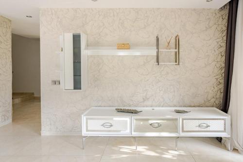 une commode blanche dans une pièce avec un mur dans l'établissement Alanya Luxury Villas 1, à Alanya
