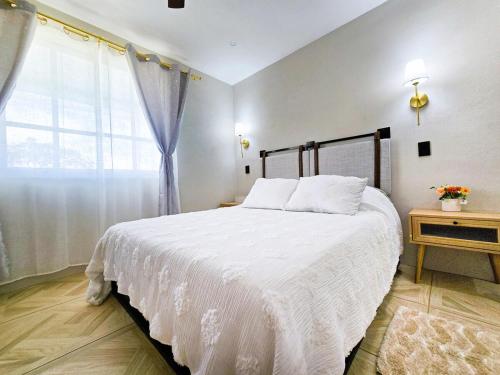 a bedroom with a white bed and a window at Casa Azul in Tolantongo Caves in Cardonal