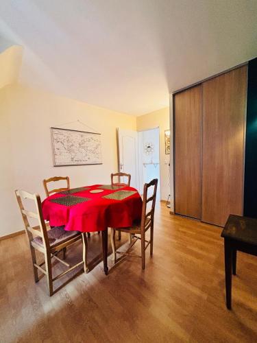 a dining room with a red table and chairs at Le Jeanne d'Arc - Appartements meublés in Gien