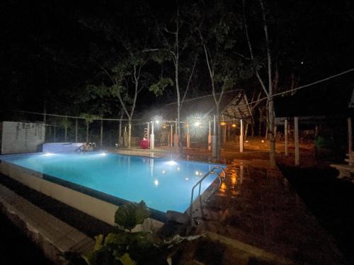 an empty swimming pool at night with lights at Ovenmin Villa in Haburugala