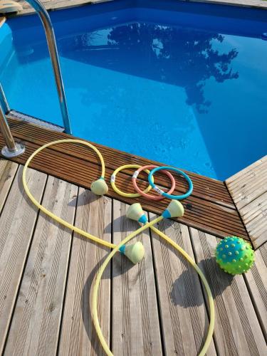 a hose sitting on a deck next to a swimming pool at Small mountain paradise with pool and hot tub in Marthod