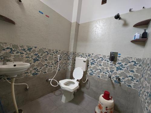 a bathroom with a toilet and a sink at Galaxy Homestay 4BHK AC in Mysore