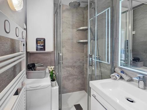 un baño con ducha y lavabo en Duplex vue mer, balcon, parking privé, en Cabourg