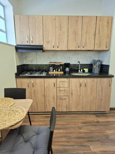 a kitchen with wooden cabinets and a table and a sink at Casa Muntú - La Candelaria in Bogotá
