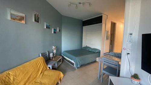 una piccola stanza con un letto e un divano di Chez Céline & Rudi a Moriani-Plage