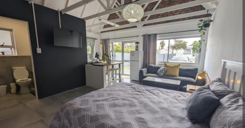 a bedroom with a bed and a living room at Central Cottage Walmer in Gqeberha