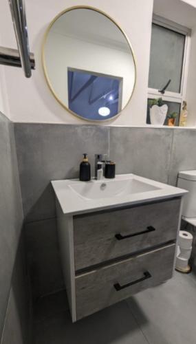 a bathroom with a sink and a mirror at Central Cottage Walmer in Gqeberha