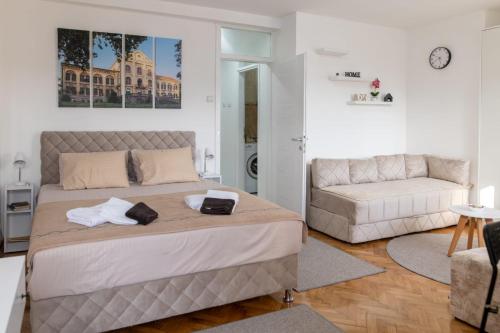 a bedroom with a large bed and a couch at Apartman Horizont in Arandjelovac