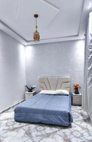 a bedroom with a bed with a blue comforter at Appartement chic et moderne à Kénitra in Kenitra