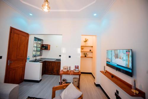 - un salon avec un bassin à poissons sur un mur dans l'établissement Heaven Hill Apartments - Arusha, à Arusha