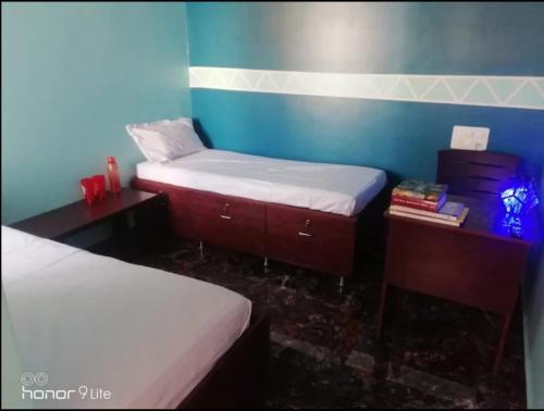 a room with two twin beds and a desk and sidx sidx sidx sidx at BLU mango PG & HOME STAY in Mysore