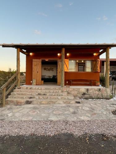 a home with a stone walkway in front of it at Vila Prana - Chalé Paz - privacidade e vista infinita in Alto Paraíso de Goiás