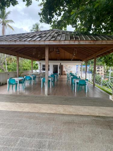 a pavilion with tables and blue tables and chairs at Samaná Suites Hotel by Habita in Santa Bárbara de Samaná