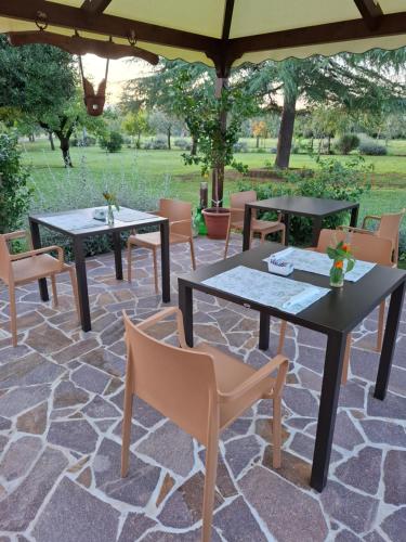 a patio with tables and chairs on a stone floor at Podere Radici - Room & Breakfast in Misano Adriatico