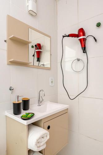 a bathroom with a sink and a red shower head at Suíte na Flor de Debora in Alto Paraíso de Goiás