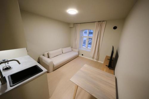 a small living room with a couch and a table at Cozy and practical studio in the city center in Ålesund