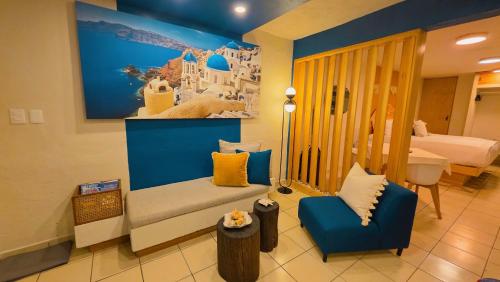 a room with a couch and two chairs and a bedroom at Santorini Suites Cozumel in Cozumel