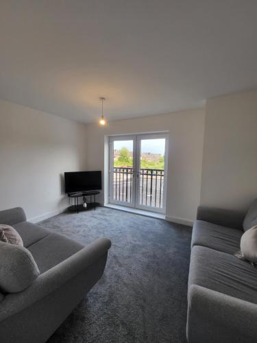 a living room with a couch and a piano at Kimberworth Family Stay in Kimberworth