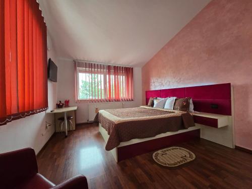 a bedroom with a large bed and a window at Pensiunea Doina Sacele in Săcele