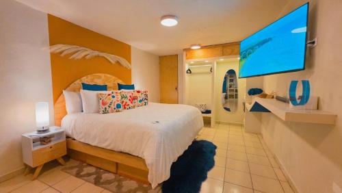 a bedroom with a large bed and a tv at Santorini Suites Cozumel in Cozumel