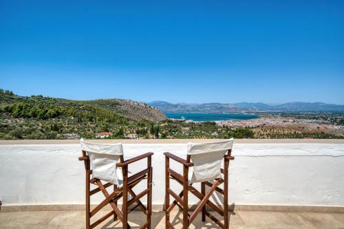 two chairs sitting on top of a white wall at Finca Nafplio Hills, spectacular sea view in Nafplio