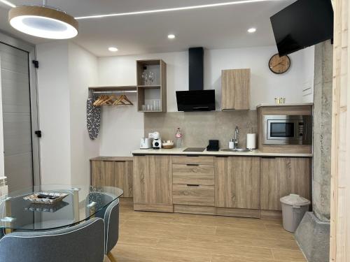 a kitchen with wooden cabinets and a glass table at El Doce Del Ferial in Solares