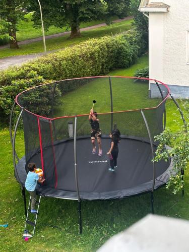 a man and two children playing on a trampoline at Luxurius flat in central Borås in Borås