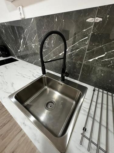 a kitchen sink with a black counter top at Luxurius flat in central Borås in Borås