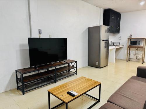 a living room with a flat screen tv and a table at Casa Jalisco, Campeche 1 in Campeche