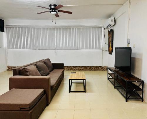 a living room with a couch and a flat screen tv at Casa Jalisco, Campeche 1 in Campeche