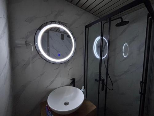 a bathroom with a sink and a shower with a mirror at Comfort corner in Skopje
